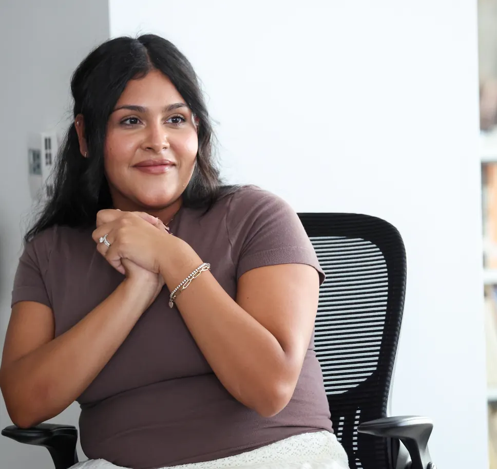 A participant smiles, hands clasped, at a Meridian Transformative Learning Lab