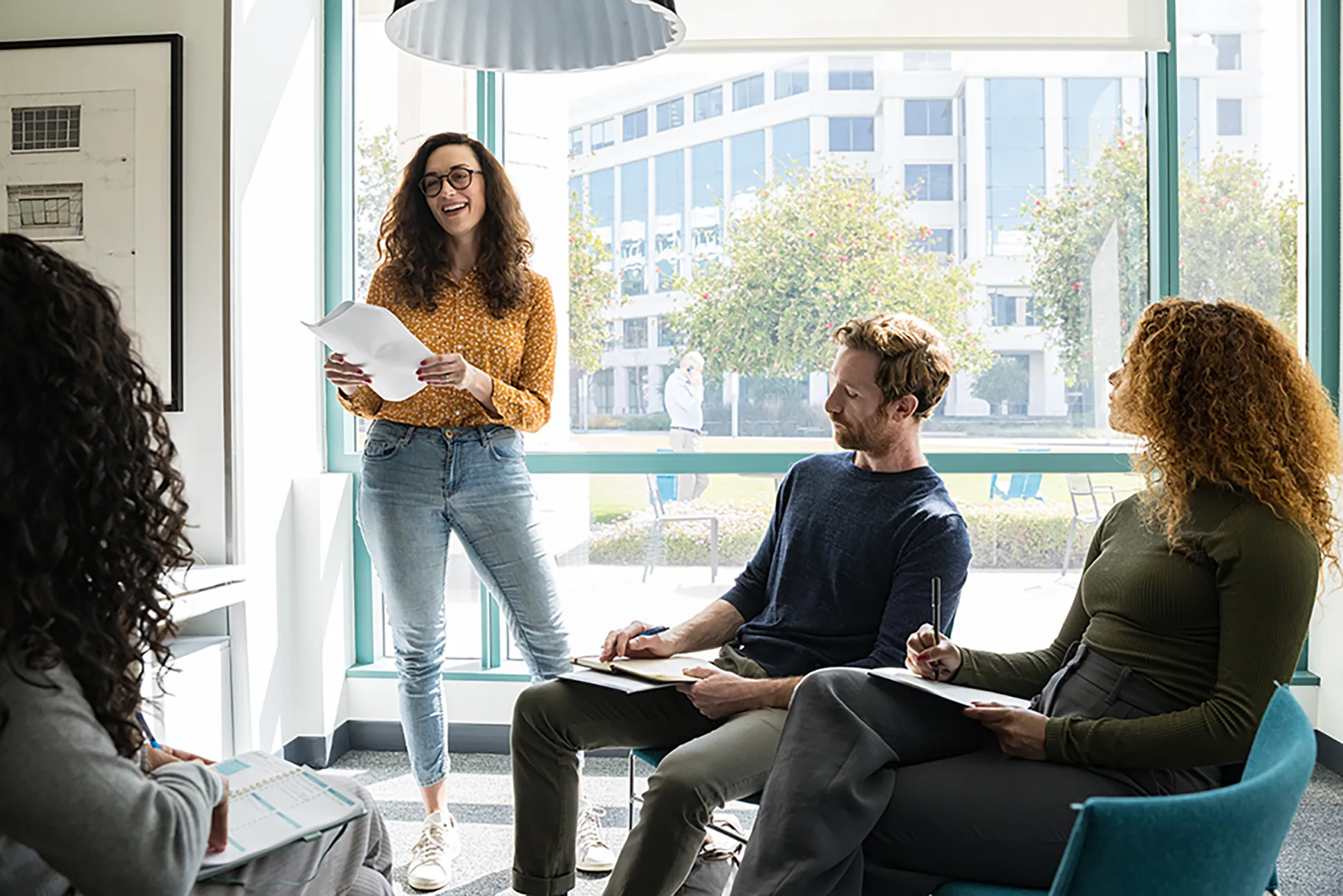 Colleagues in discussion around a meeting room