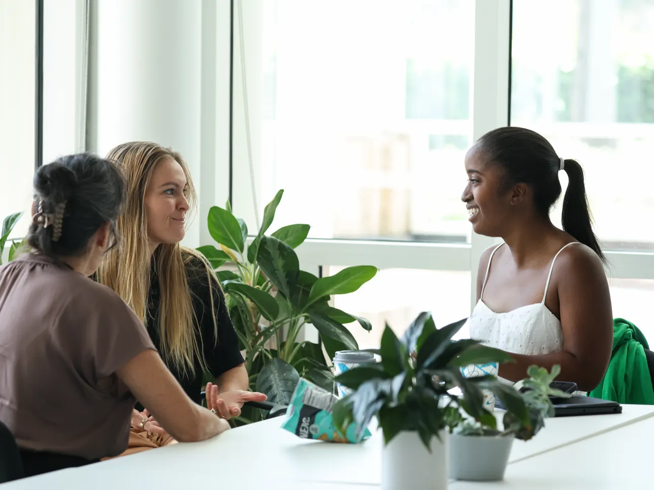 Three participants talk around a table at a Meridian Transformative Learning Lab