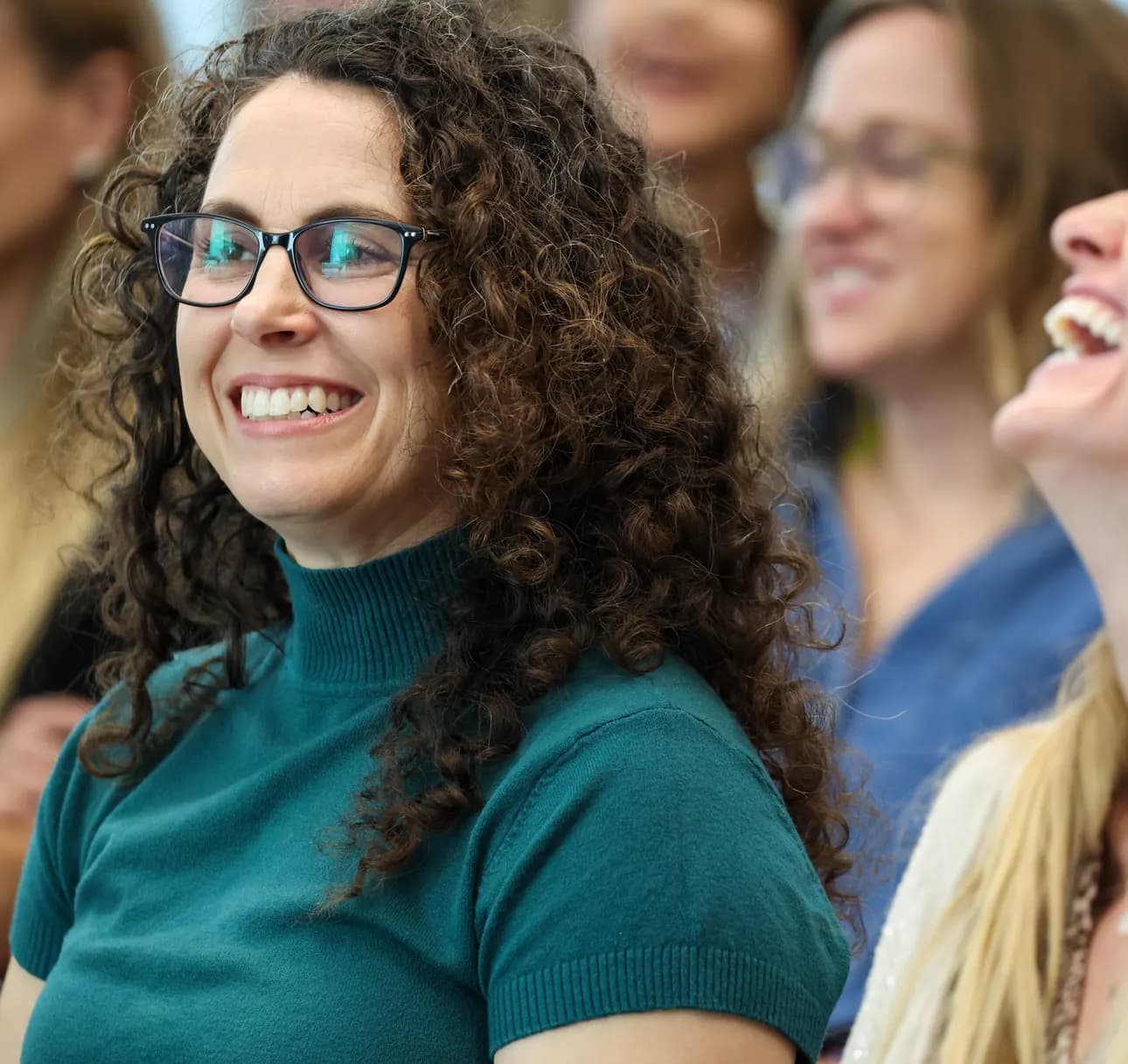 A participant smiles while listening at a Meridian Transformative Learning Lab