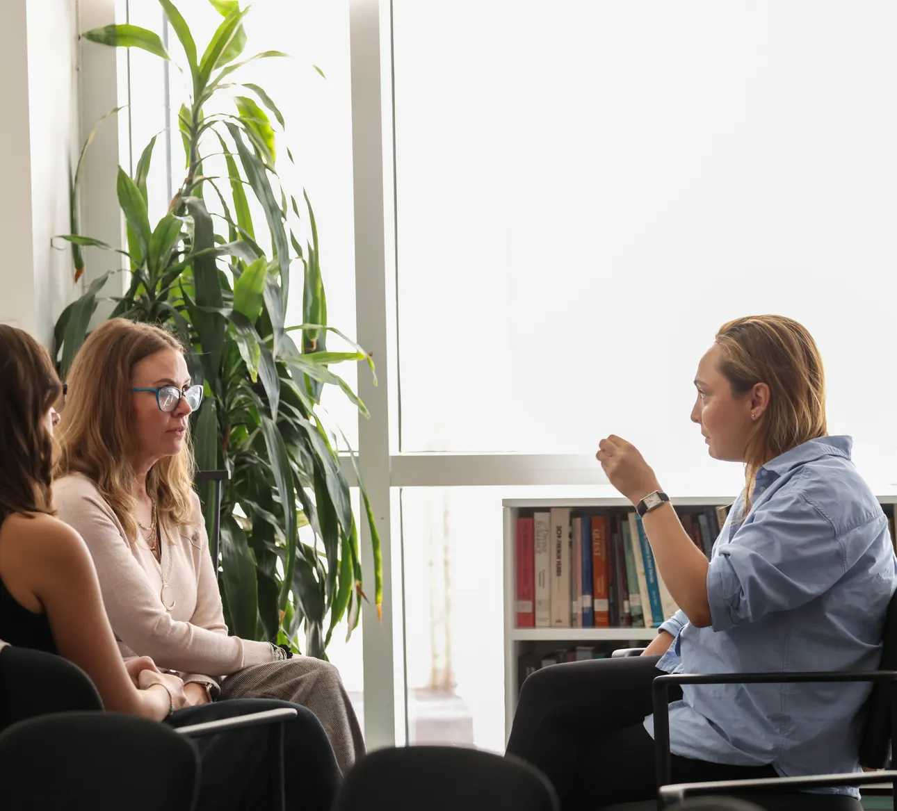 Three participants in a small-group session by the window at a Meridian Transformative Learning Lab