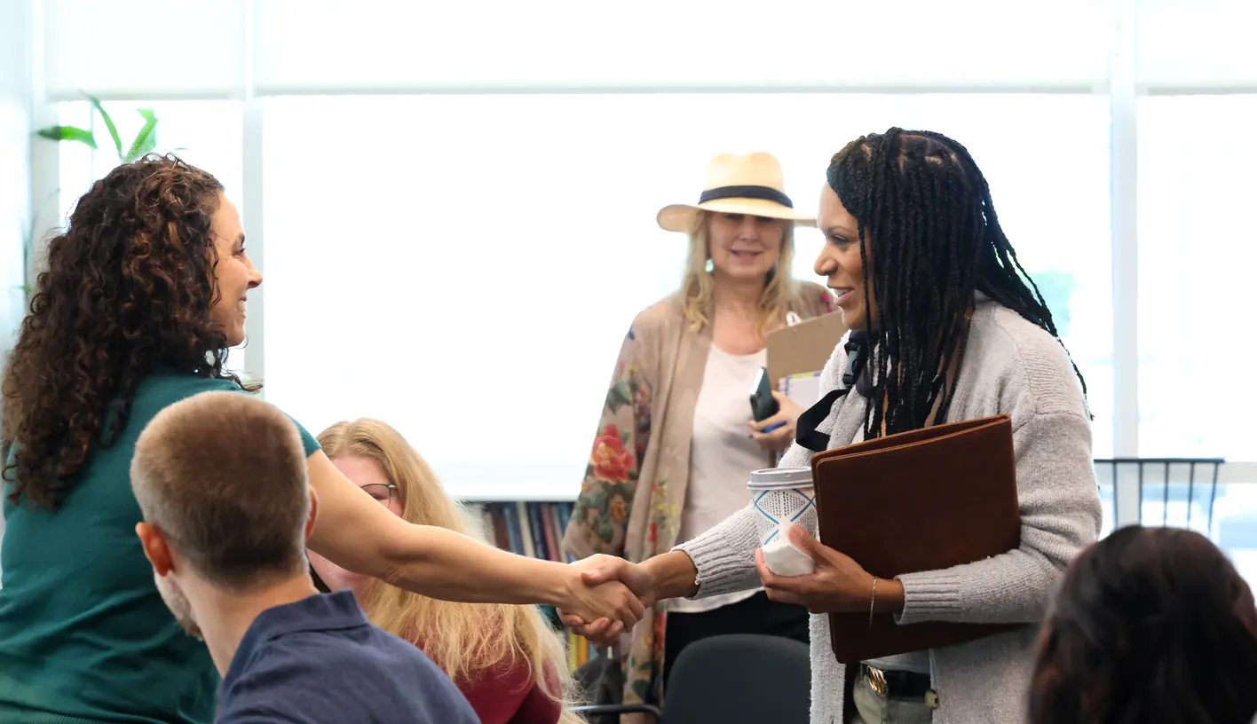 Participants greet one another with a handshake at a Meridian Transformative Learning Lab