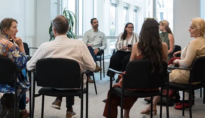 Students and faculty engaged in a face-to-face discussion in a bright classroom setting