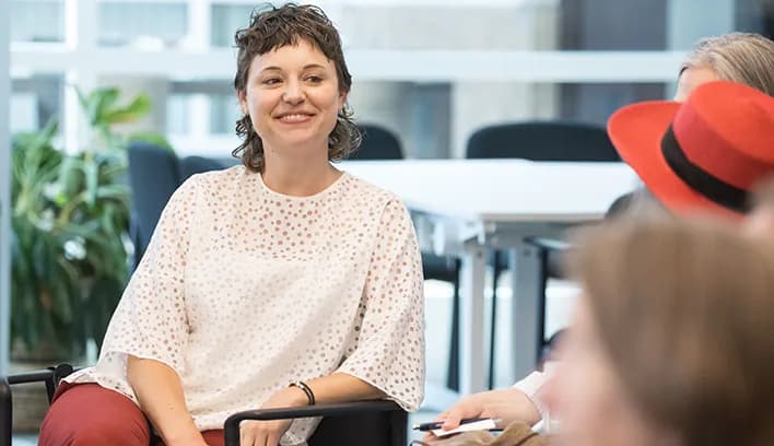 Smiling student engaging in conversation in a campus common area