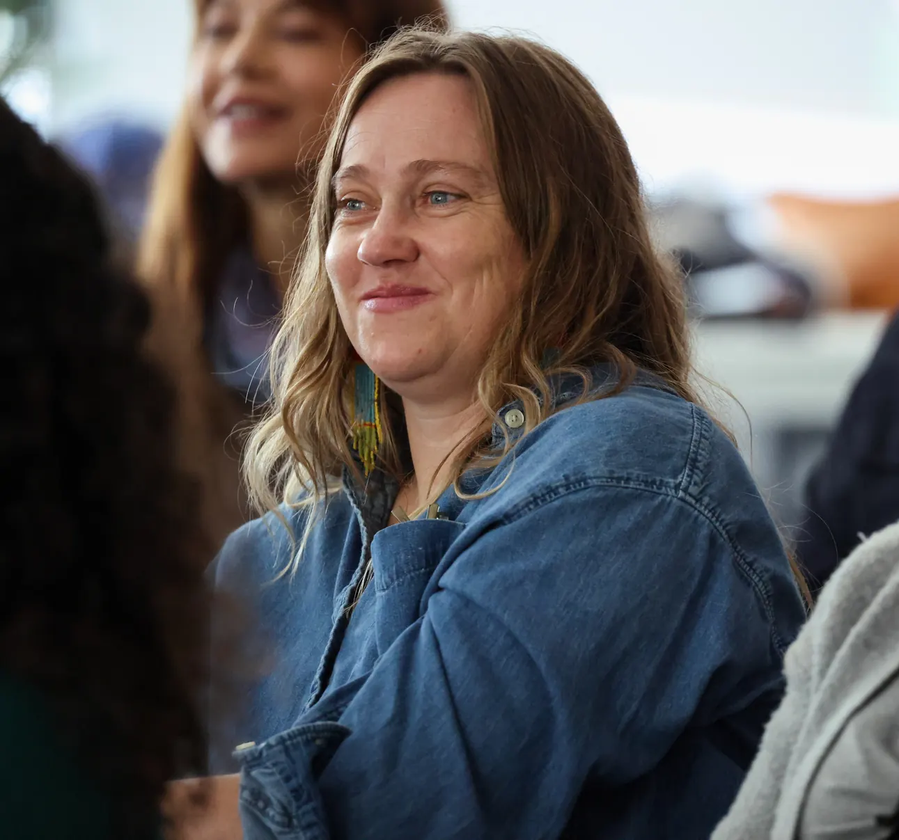 A participant smiles while listening at a Meridian Transformative Learning Lab