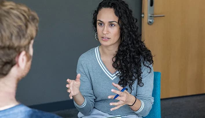 Student speaking with an instructor in a small-group discussion
