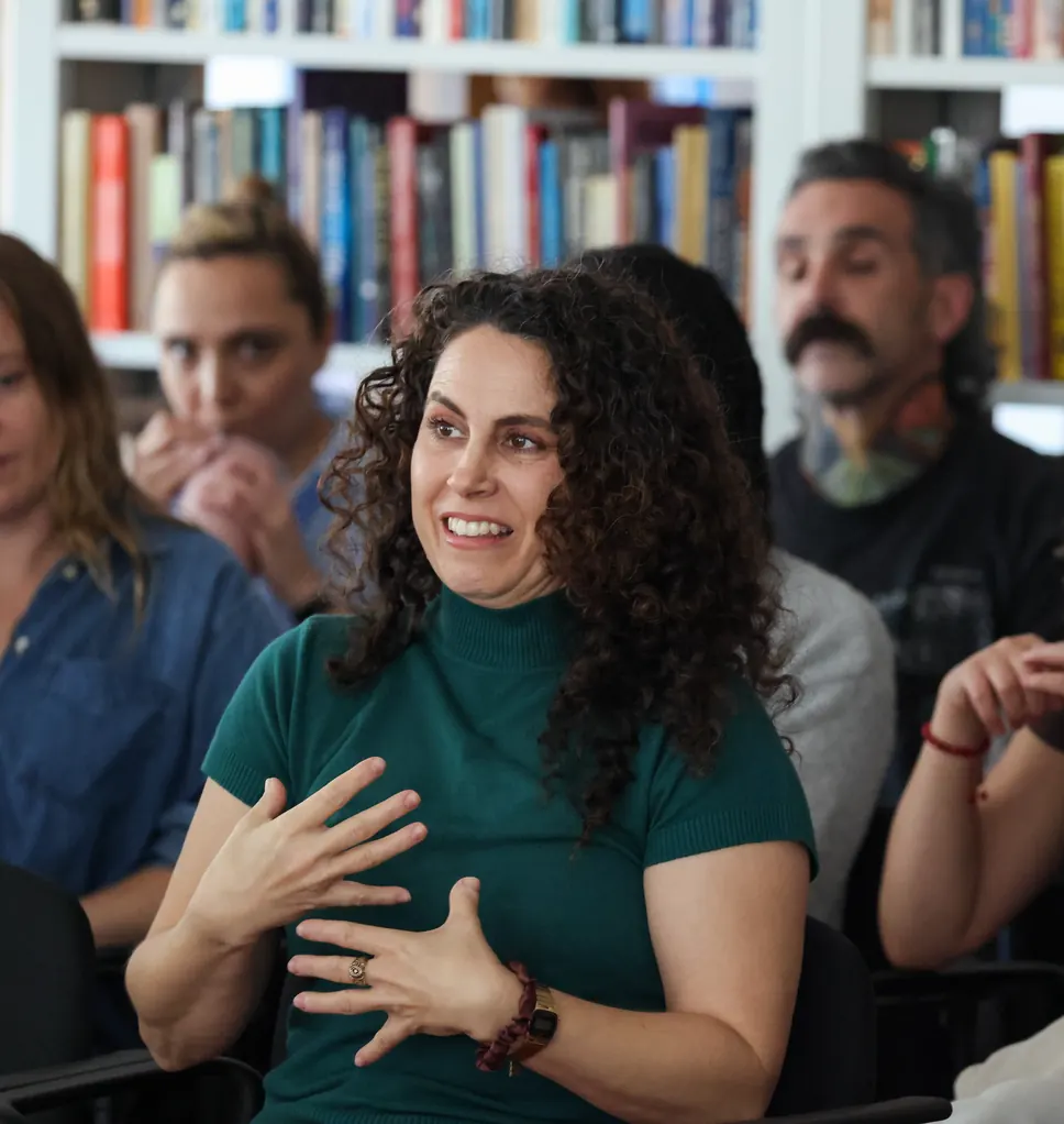 A participant speaks with her hands during a group session at a Meridian Transformative Learning Lab