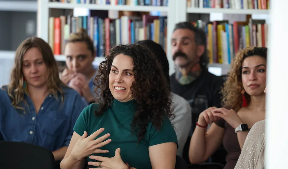 A participant speaks with her hands during a group session at a Meridian Transformative Learning Lab