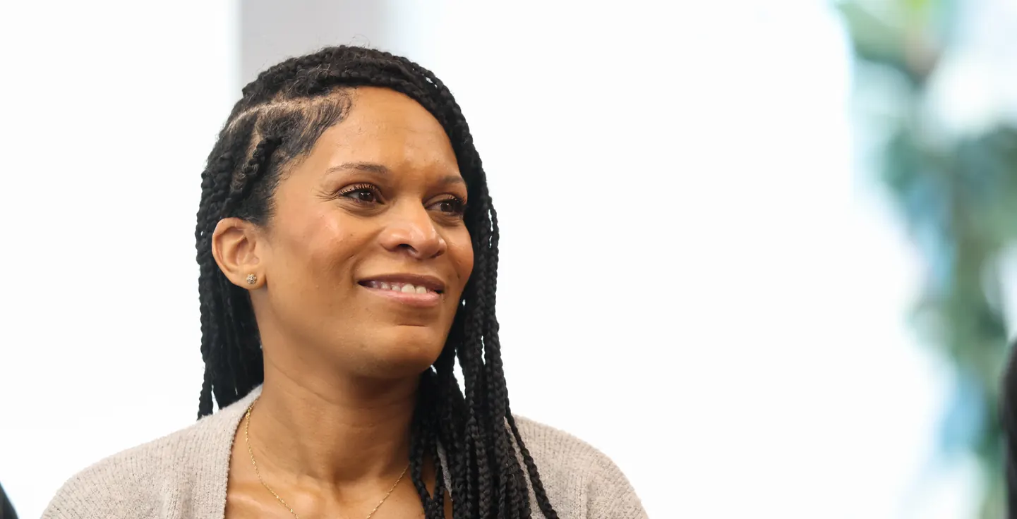 A participant smiles while listening at a Meridian Transformative Learning Lab