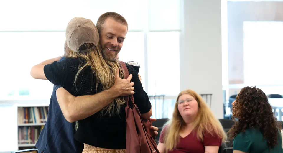 Two participants embrace as a session begins at a Meridian Transformative Learning Lab