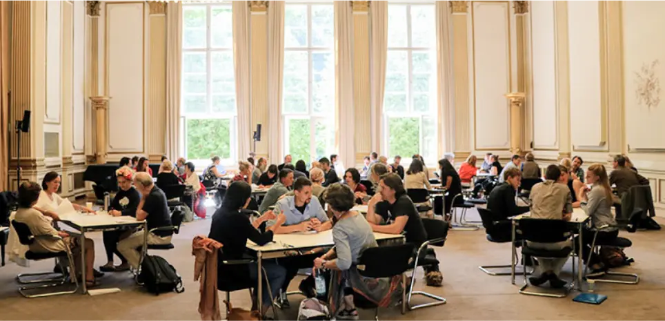 groups gather and discuss around tables