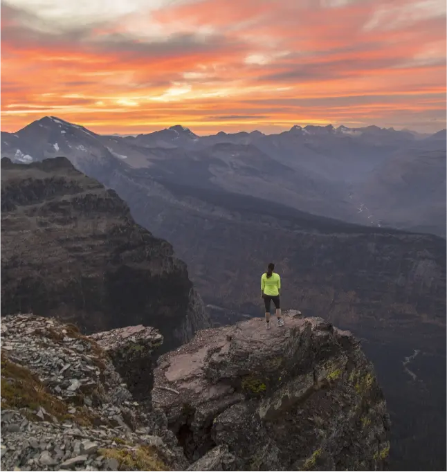 a hiker takes in a breathtaking view of mountains and valleys