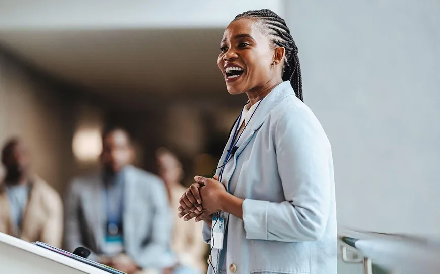 A woman speaking confidently at a podium during a professional event.