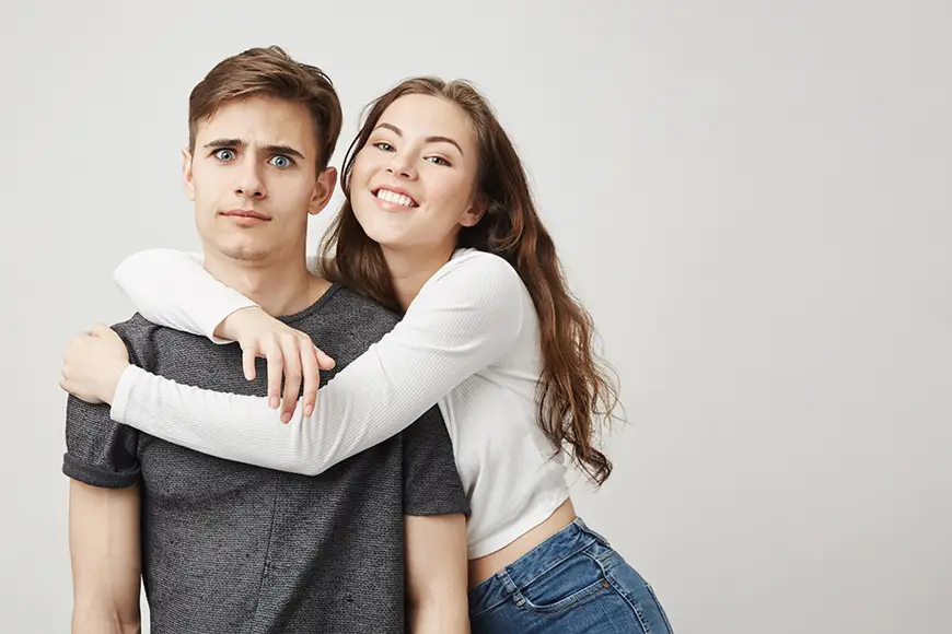 Uneasy male expression with a clinging partner, reflecting codependent behavior