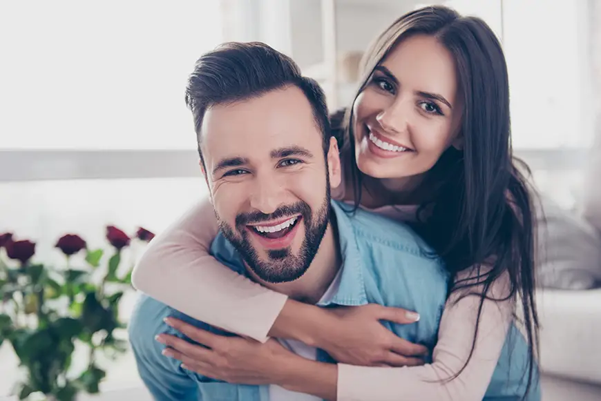 Happy couple hugging and smiling in a bright, cozy room