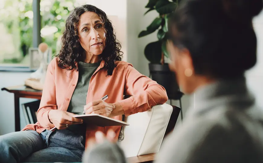 Health and well-being coach taking notes during a client conversation.