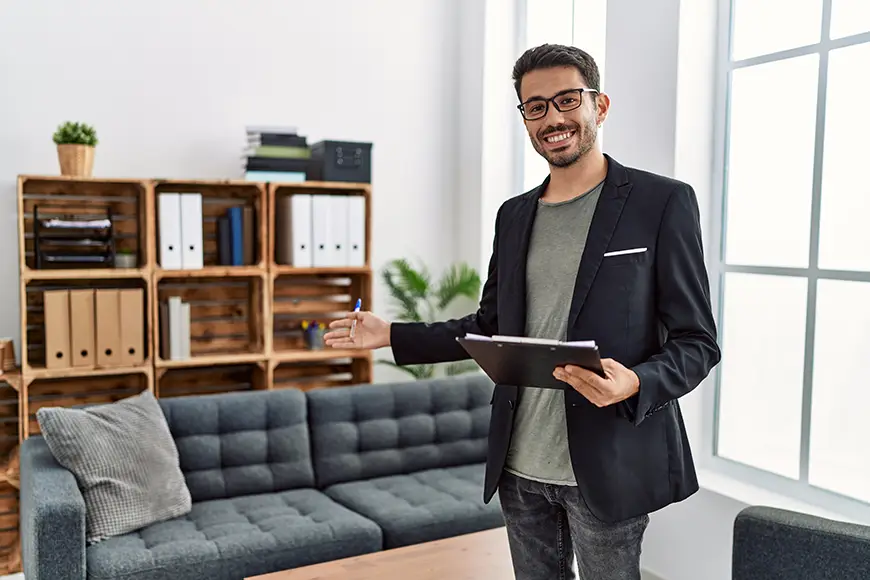 A friendly clinical psychologist welcoming clients with a smile in a modern therapy office