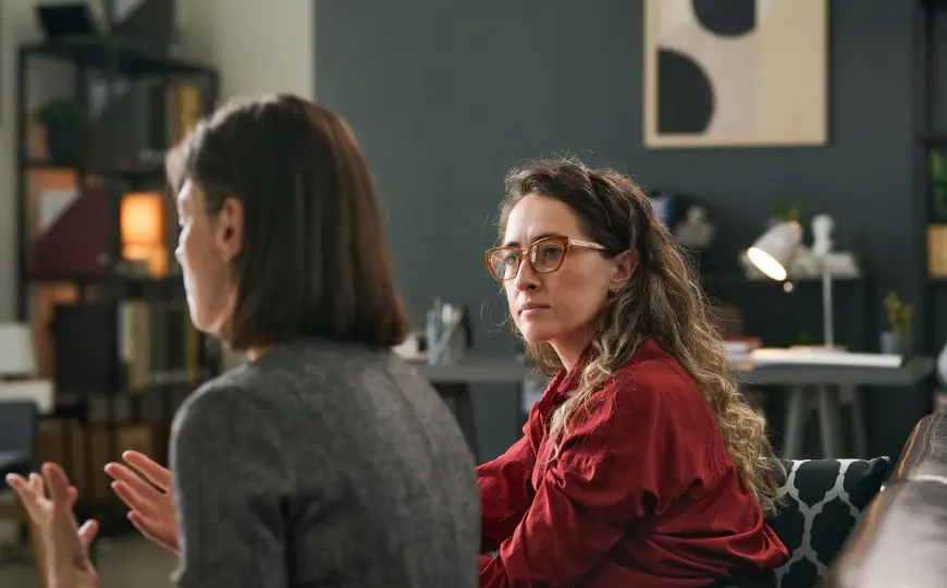Therapist listening attentively during an in-person counseling session.