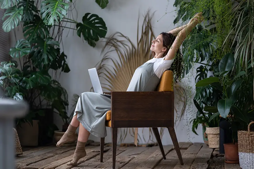 A remote worker stretches in a chair
