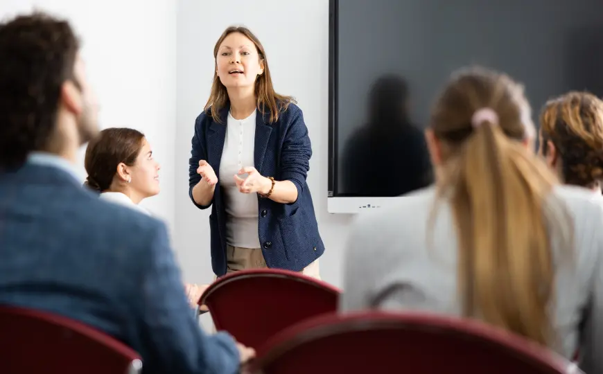 A graduate student engaged in an embodied learning exercise during a somatic psychology training session.