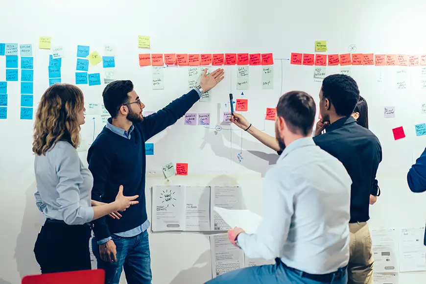 A business team maps out strategies on an erasable board