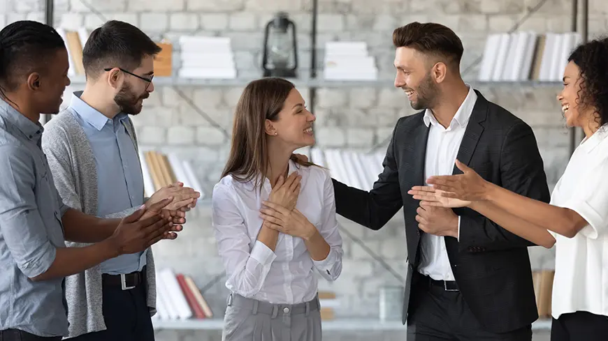 A woman receives praise from four coworkers.